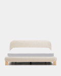 Cama desenfundable Odina bouclé crudo y patas de madera maciza de fresno acabado tono natural para colchón de 180 x 200 cm.