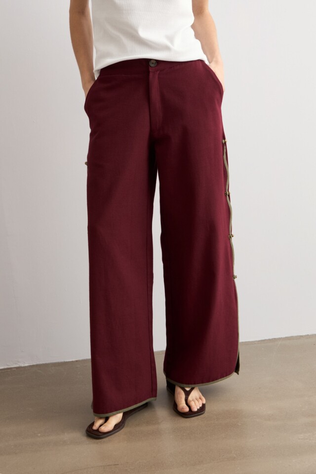 Pantalón con vivo y botones laterales ciruela