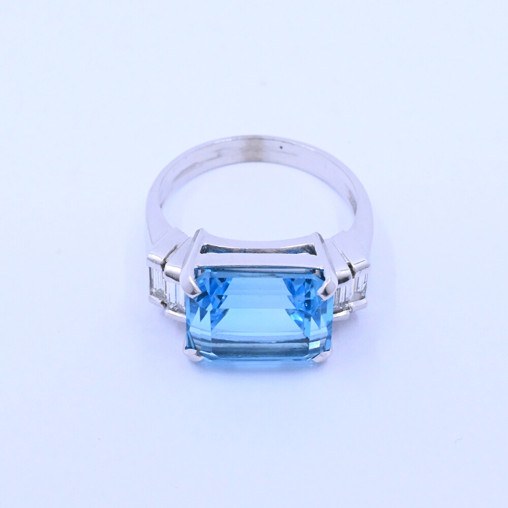 Anillo oro 18k blanco con topacio azul central y 4 brillantes baguette. Anillo oro 18k blanco con topacio azul central y 4 brillantes baguette.