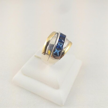Anillo de plata 925 con doublé de oro 18K con circonias de color azul. Ancho superior 1.4 cm. Anillo de plata 925 con doublé de oro 18K con circonias de color azul. Ancho superior 1.4 cm.
