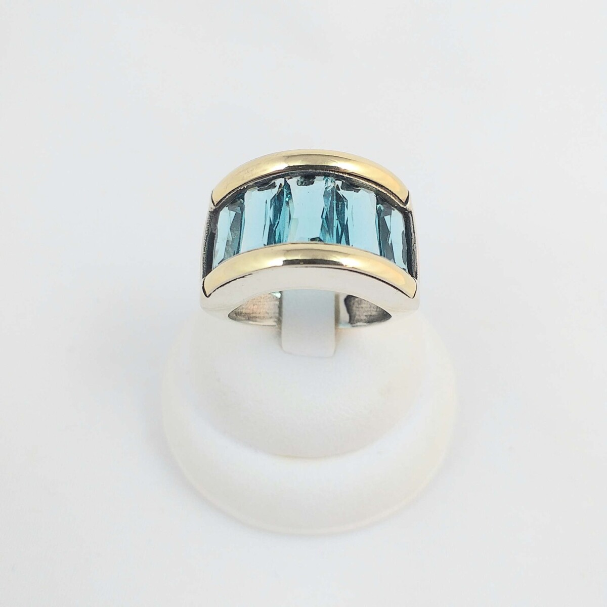 Anillo de plata 925 con detalles double en oro 18ktes. con circonia color celeste imitación topacio. 