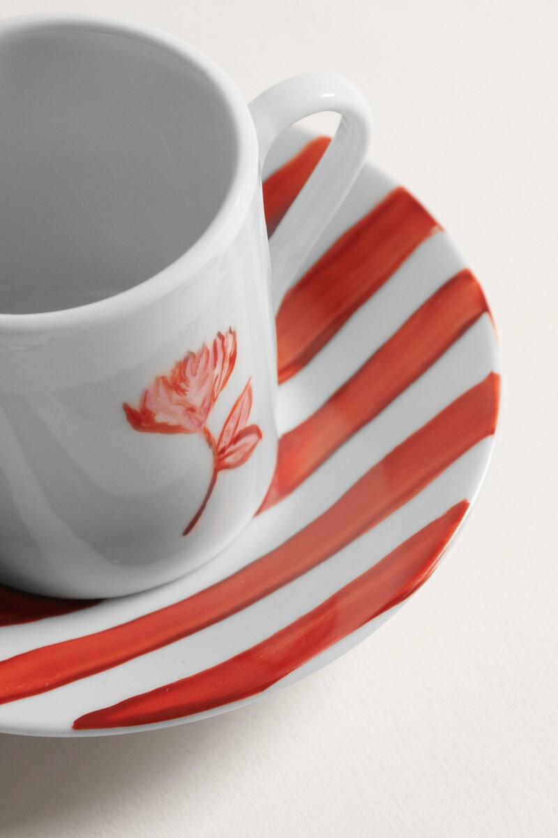 Taza de café con plato terracota en flor