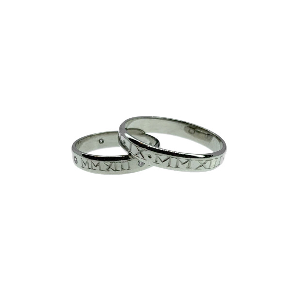 Par de alianzas de oro blanco 18k con fecha en números romanos- una con brillantes Par de alianzas de oro blanco 18k con fecha en números romanos- una con brillantes