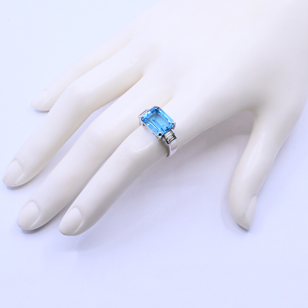 Anillo oro 18k blanco con topacio azul central y 4 brillantes baguette. Anillo oro 18k blanco con topacio azul central y 4 brillantes baguette.