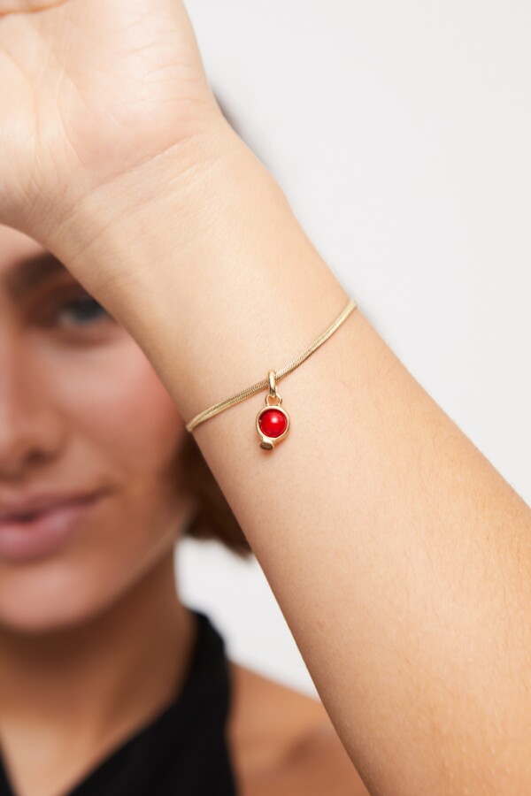 CHARM BAÑADO EN ORO 18K CON PIEDRA ROJA. Charm