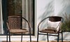 Silla exterior de metal y ratán con apoyabrazos Marrón