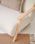 Butaca Meghan de borreguito blanco y patas de madera maciza de fresno con acabado natural