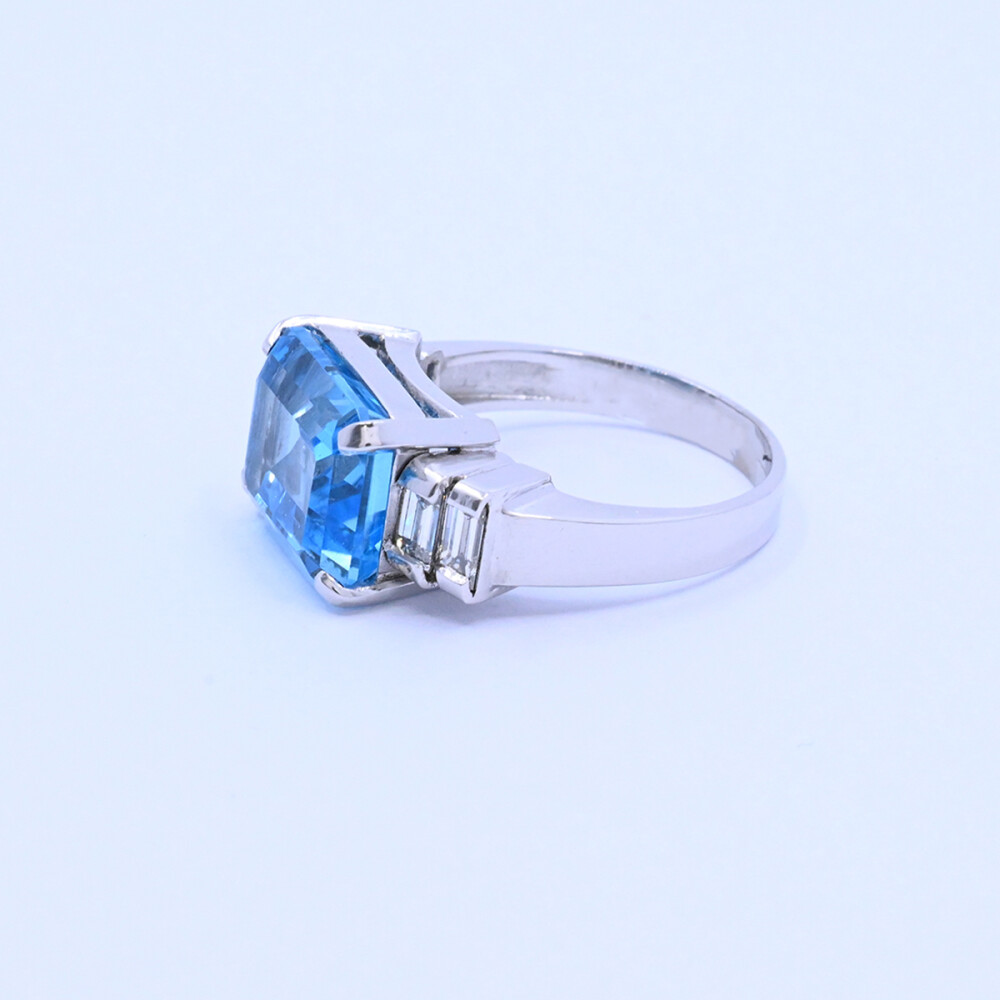 Anillo oro 18k blanco con topacio azul central y 4 brillantes baguette. Anillo oro 18k blanco con topacio azul central y 4 brillantes baguette.