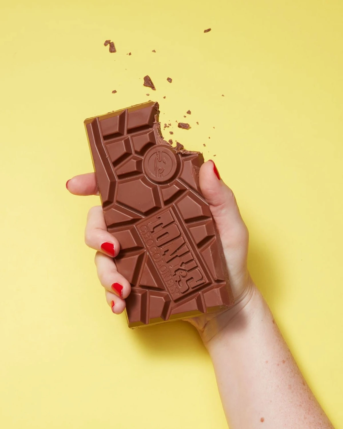 Tableta Tony's Chocolonely leche 32% estallando en pedazos