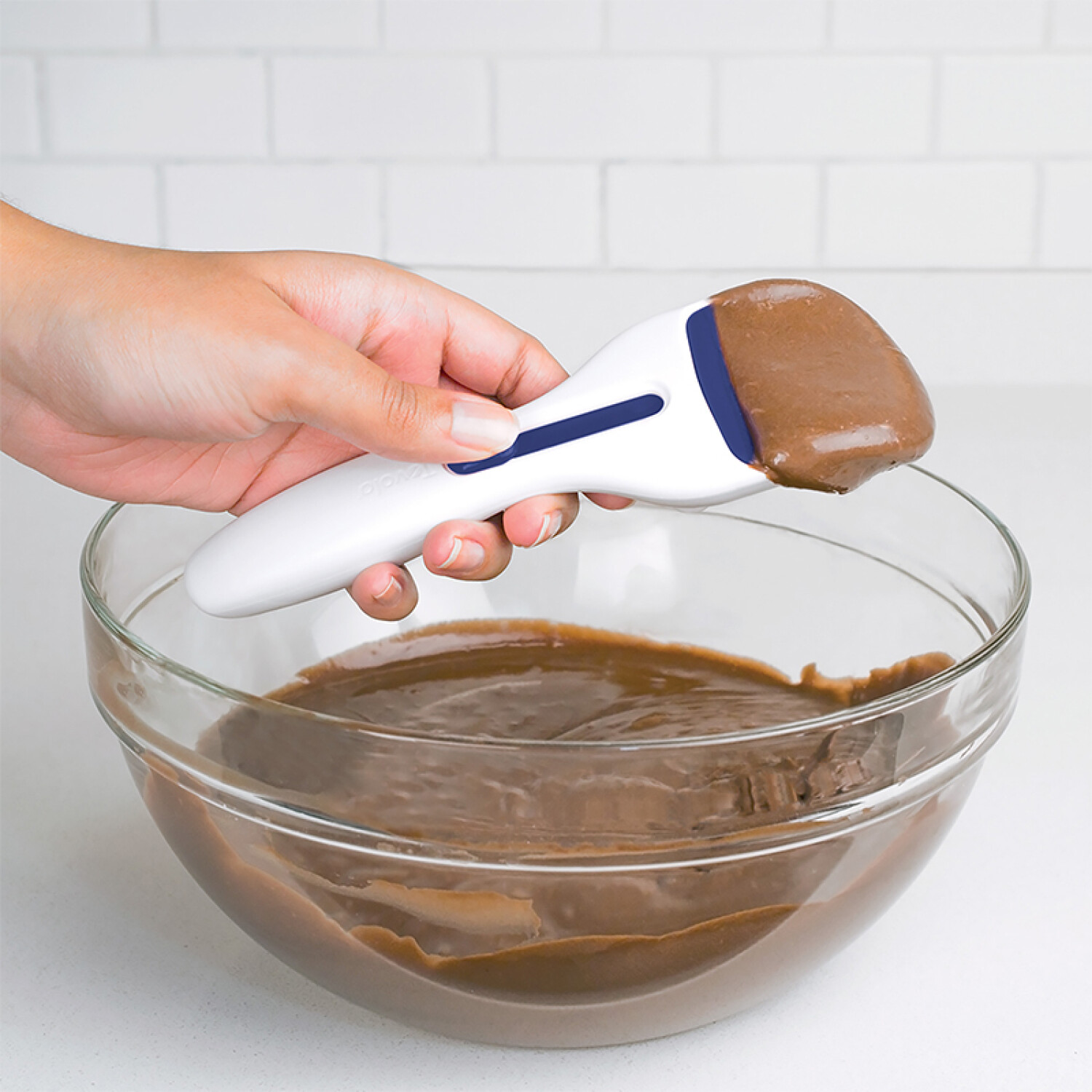 Sacar la masa con una cuchara de masa en un molde para cupcakes