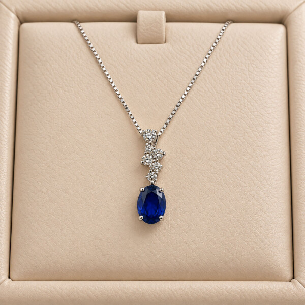 Colgante Odette de Oro Blanco 18k con Brillantes y Zafiro Azul (incluye cadena de 40cm) Colgante Odette de Oro Blanco 18k con Brillantes y Zafiro Azul (incluye cadena de 40cm)