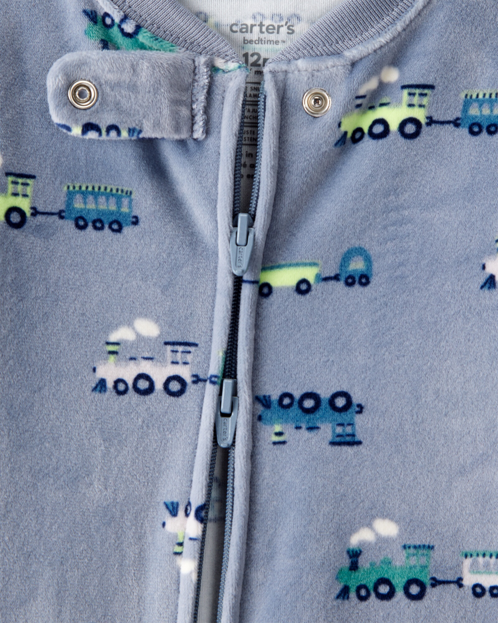 Pijama una pieza de DreamPlush, con pie, azul, diseño trenes. Talles 12-24M Sin color