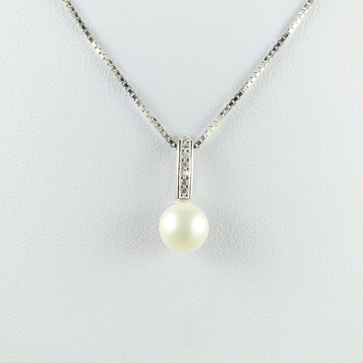 Colgante con perla natural de río 8 mm y 7 circonias engarzadas a al inglesa, con cadena en plata 925 y rodio. 