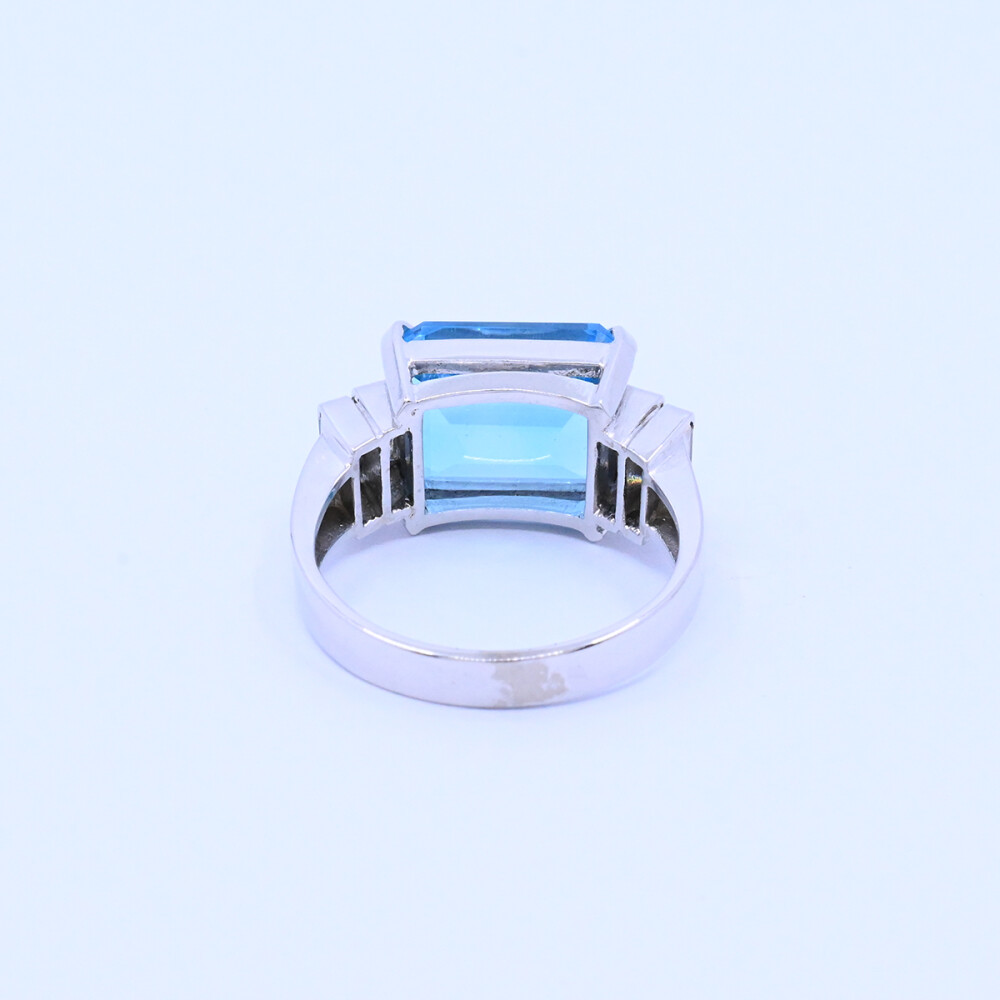 Anillo oro 18k blanco con topacio azul central y 4 brillantes baguette. Anillo oro 18k blanco con topacio azul central y 4 brillantes baguette.