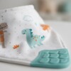 Babero bandana con mordillo BUBA dino grey pastel