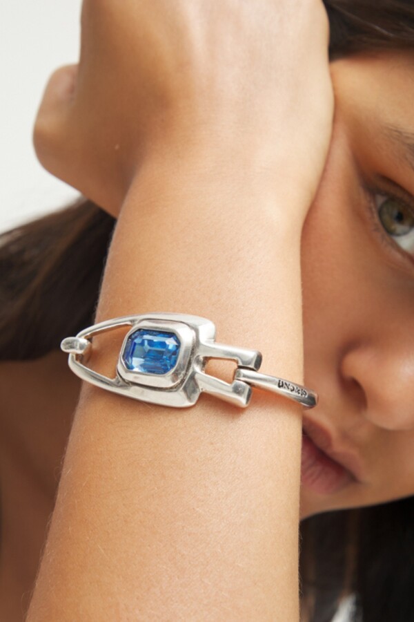 PULSERA SEMIRIGIDA DE ALEACIÓN DE METALES BAÑADA EN PLATA DE LEY CON CRISTAL FACETADO AZUL Pulsera