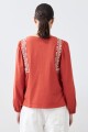 Remera boho con bordados lacre