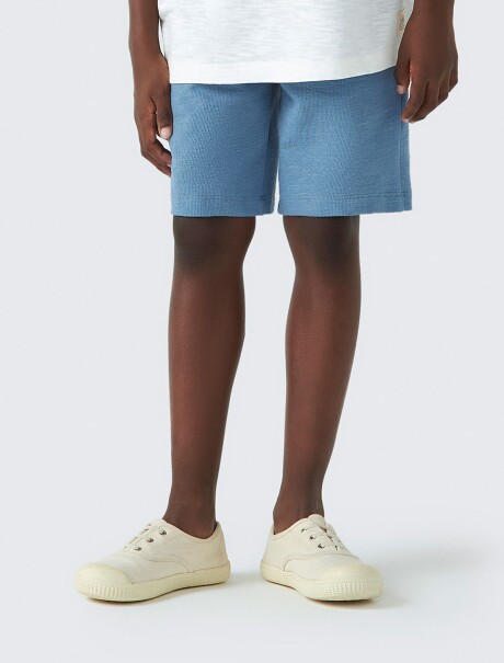 BERMUDA INFANTIL CON BOLSILLO CELESTE