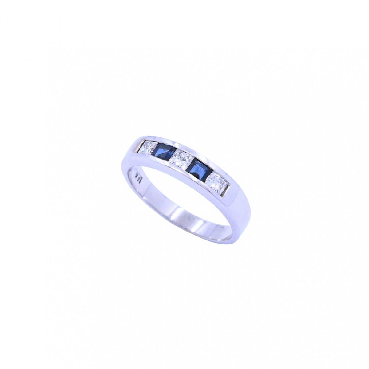 Anillo medio sin fin oro 18 k blanco, engarce carril con brillantes y zafiros azules. 