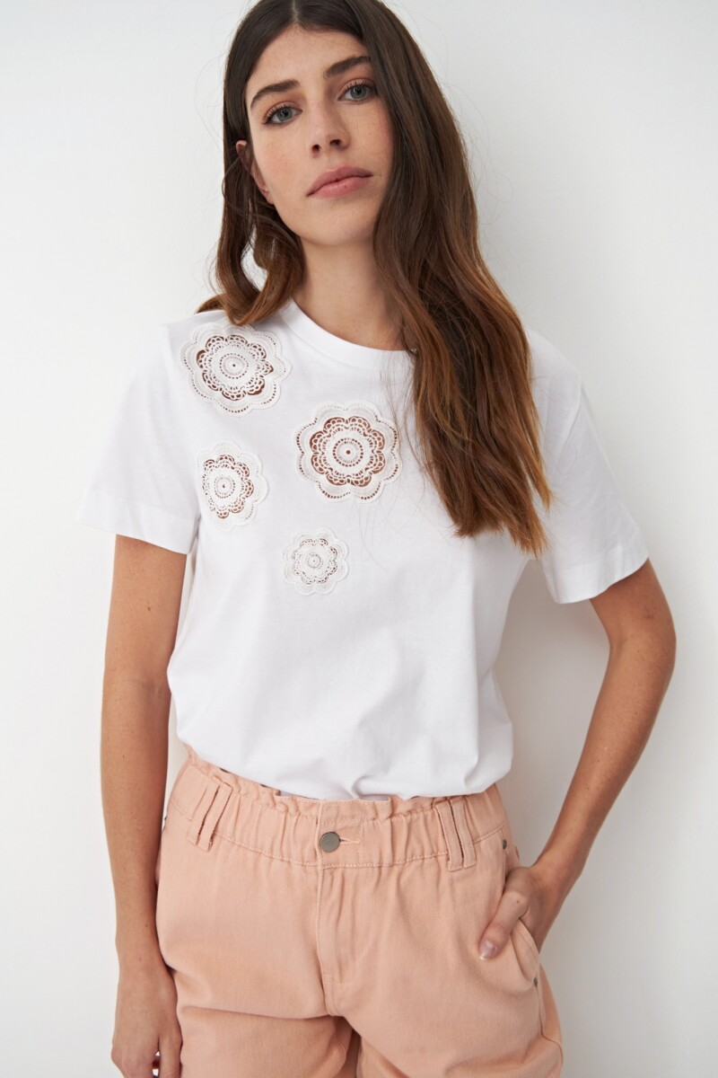 Remera escote base con parches de crochet blanco